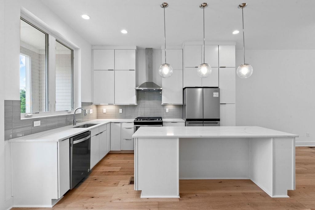 310 Mallard Avenue Durham, NC 27701 - Photo 14 of 41 a kitchen with stainless steel appliances granite countertop a sink a stove and a refrigerator