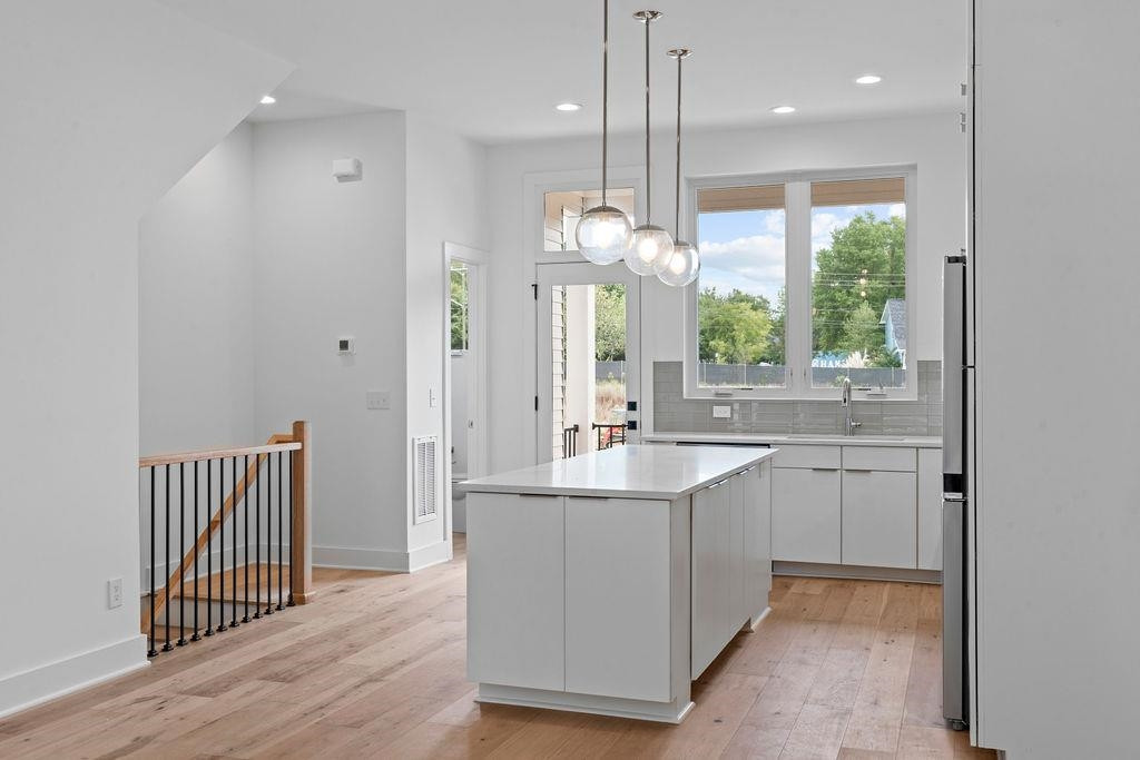 310 Mallard Avenue Durham, NC 27701 - Photo 3 of 41 a kitchen with kitchen island granite countertop a sink cabinets and wooden floor