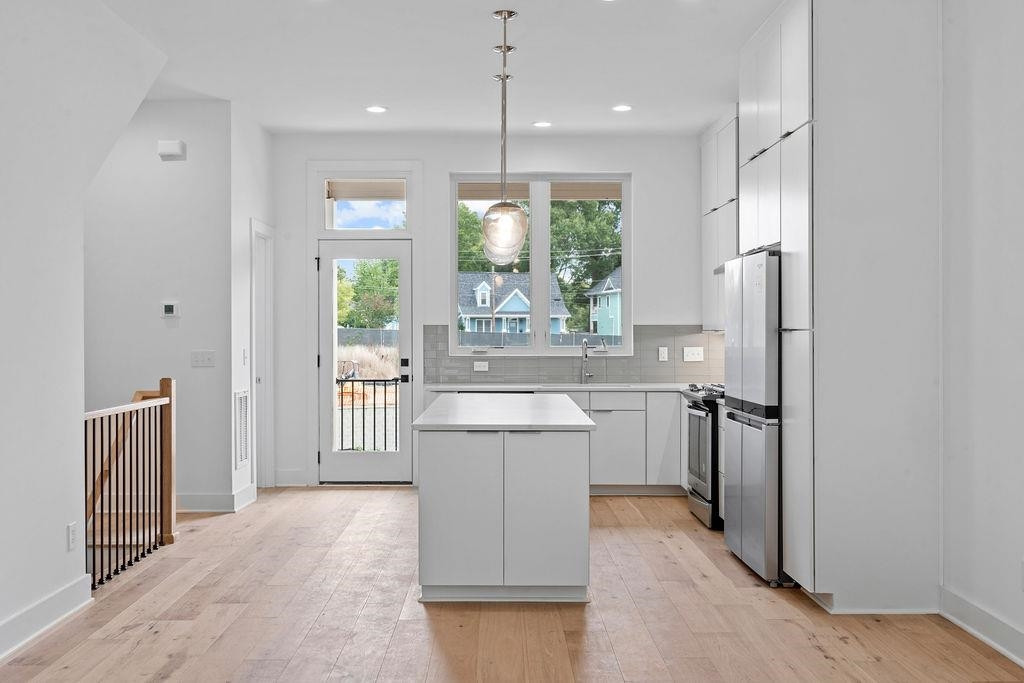 310 Mallard Avenue Durham, NC 27701 - Photo 9 of 41 a large kitchen with a refrigerator a sink dishwasher and a fireplace