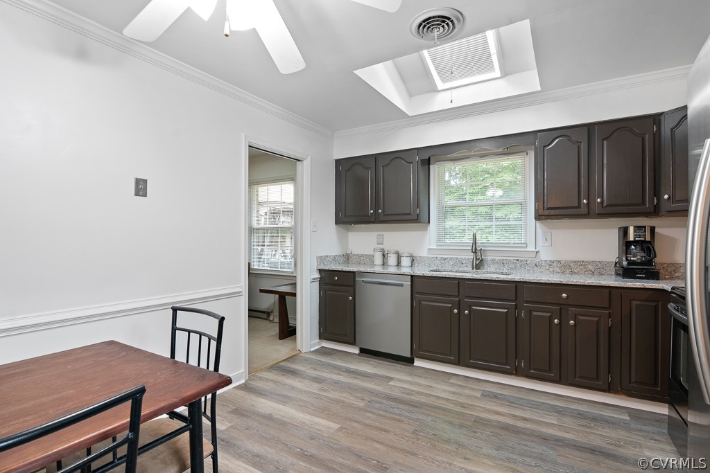 9441 Trails End Road Midlothian, VA 23112 - Photo 9 of 40 a kitchen with stainless steel appliances granite countertop a stove top oven a sink dishwasher a dining table and chairs with wooden floor