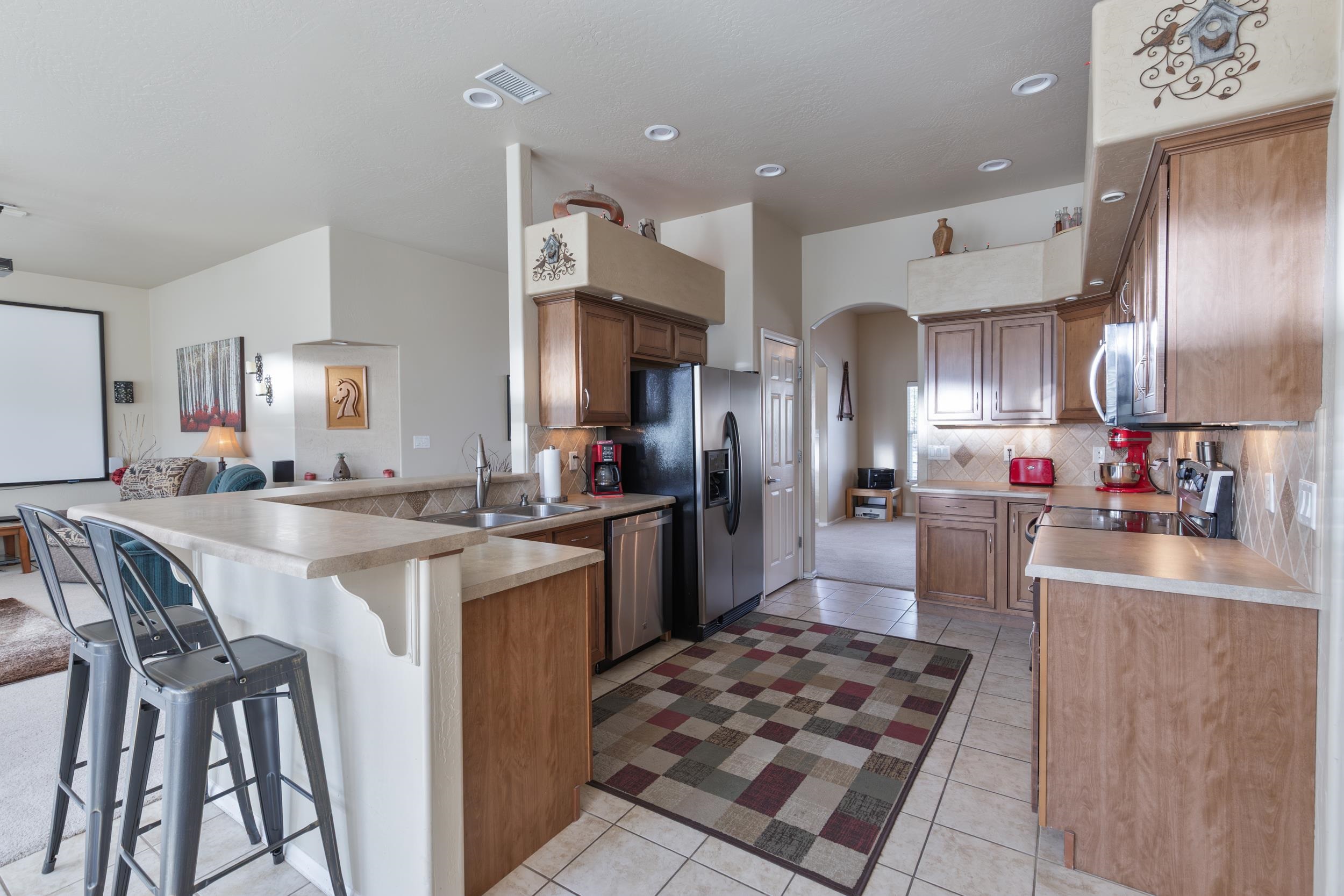 544 Hemlock Drive Fruita, CO 81521 - Photo 11 of 36 a large kitchen with stainless steel appliances kitchen island granite countertop a sink stove and refrigerator