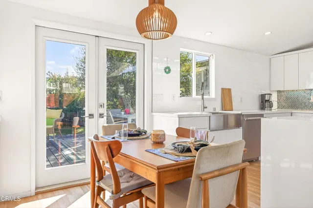 a dining room with furniture a chandelier and wooden floor