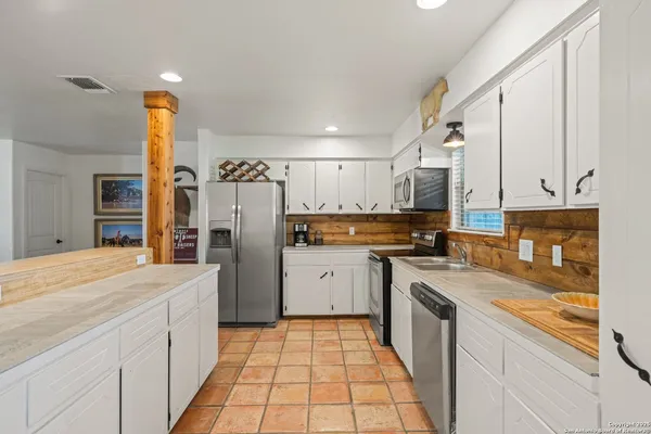 a kitchen with a sink refrigerator and microwave