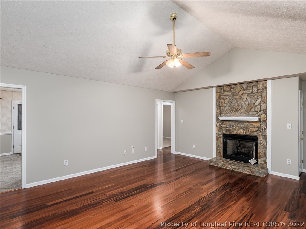 847 Turkey Ridge Drive Fayetteville, NC 28314 - Photo 13 of 31 an empty room with wooden floor fireplace and fan