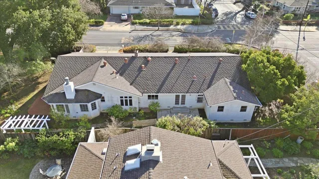 an aerial view of a house with a yard and large trees