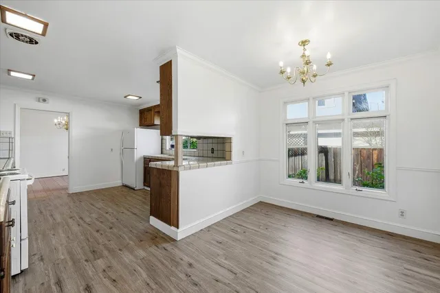 a kitchen with stainless steel appliances granite countertop a stove a sink dishwasher and wooden cabinets with wooden floor