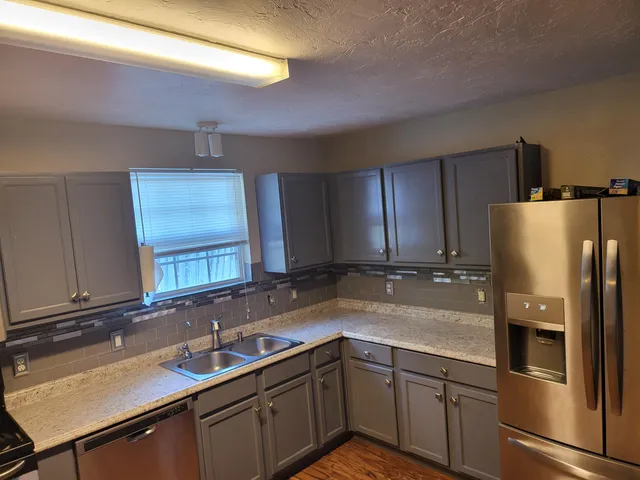 a kitchen with stainless steel appliances a sink stove and refrigerator