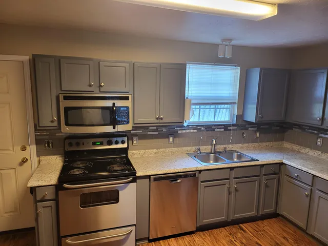a kitchen with a sink stove and microwave