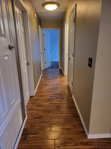 a view of a hallway with wooden floor and staircase