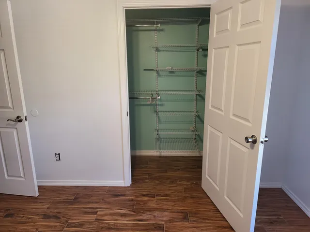 a view of a room with wooden floor and fan