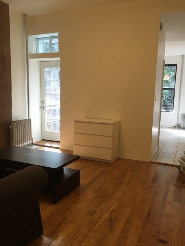 518 Bainbridge Street, Unit 1B Brooklyn, NY 11233 - Photo 3 of 7 a living room with furniture and large window