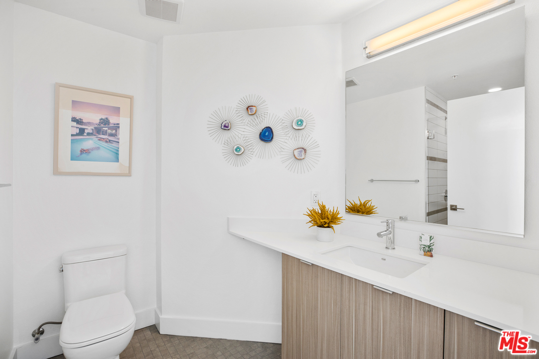 13448 Beach Avenue, Unit PH7314 Marina del Rey, CA 90292 - Photo 17 of 22 a bathroom with a sink mirror vanity and toilet
