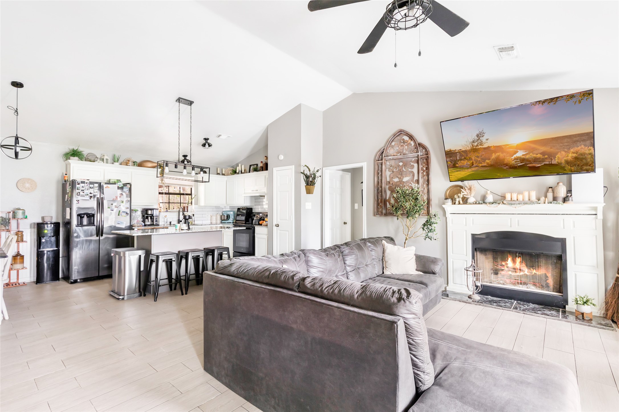 9660 Fostoria Road Cleveland, TX 77328 - Photo 17 of 31 a living room with furniture a fireplace and a flat screen tv