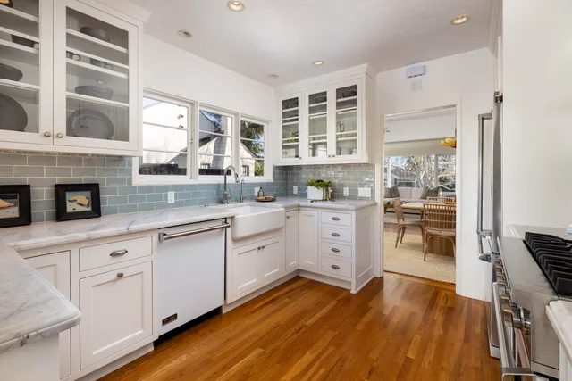 a kitchen with stainless steel appliances white cabinets and wooden floor