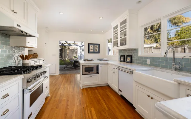 a kitchen with stainless steel appliances a stove top oven a sink a counter space and cabinets