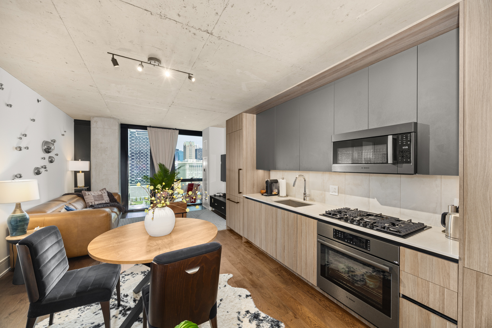 Undisclosed Address Chicago, IL 60607 - Photo 15 of 44 a kitchen with stainless steel appliances kitchen island granite countertop a stove a sink dishwasher a dining table and chairs with wooden floor