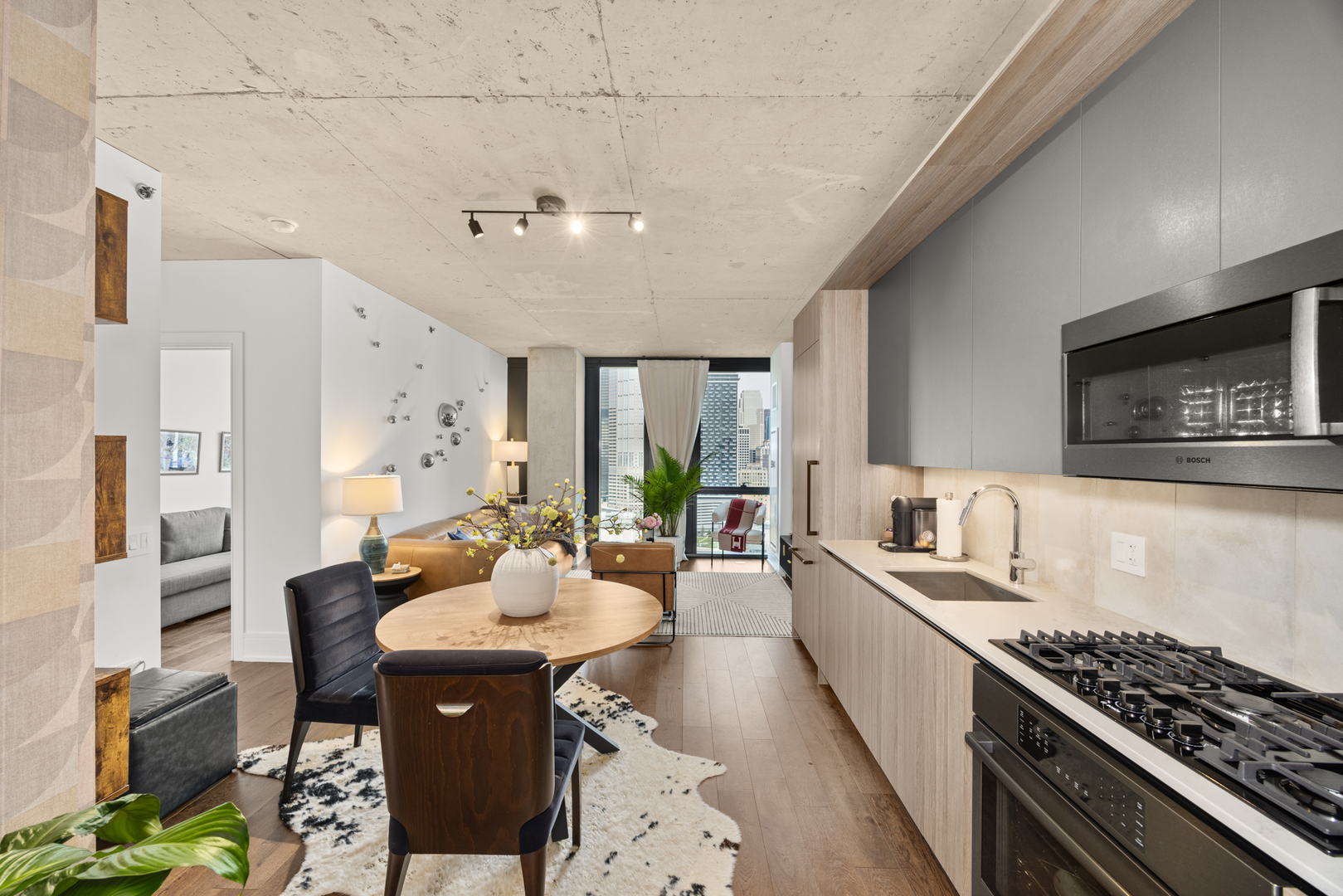 Undisclosed Address Chicago, IL 60607 - Photo 16 of 44 a large kitchen with stainless steel appliances a stove a sink dishwasher a dining table and chairs with wooden floor
