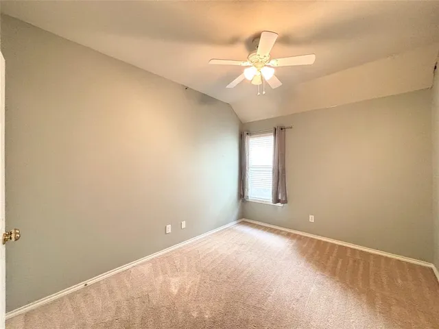 an empty room with windows and chandelier fan