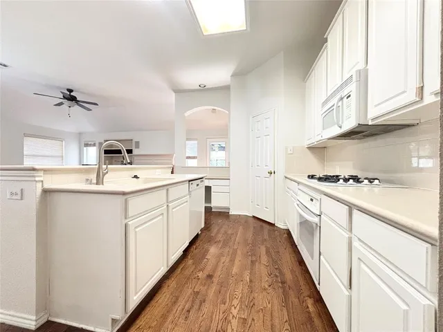 a kitchen with cabinets a sink and appliances