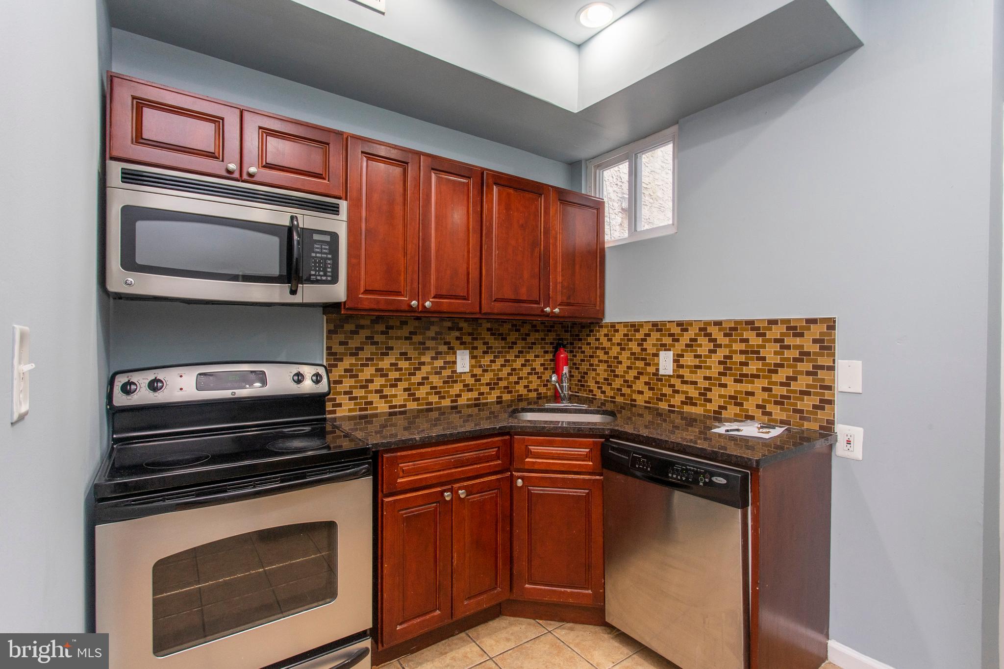 2016 North 18th Street, Unit 2 Philadelphia, PA 19121 - Photo 18 of 23 a kitchen with stainless steel appliances granite countertop a stove microwave and sink