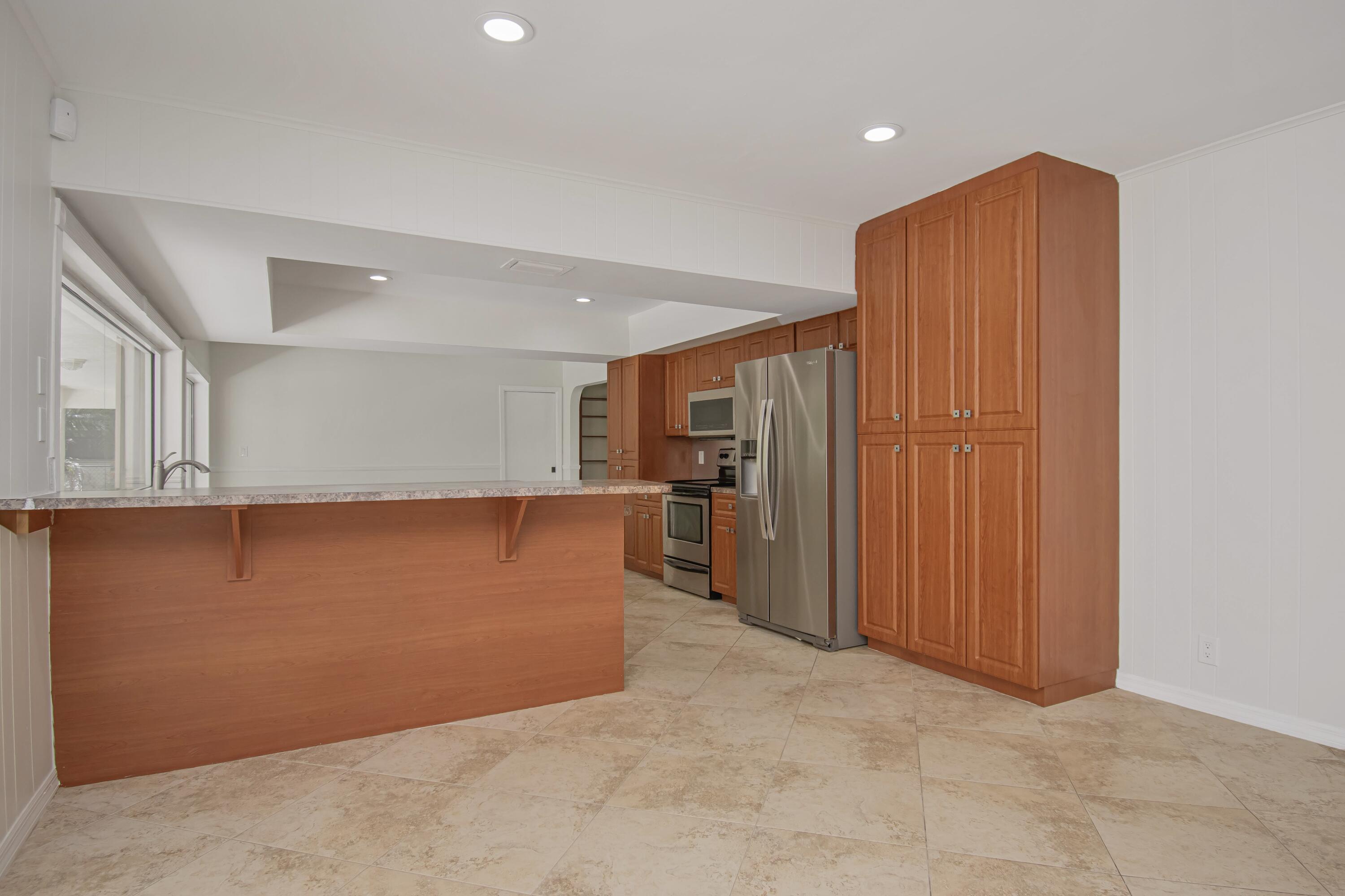 6749 South Grande Drive Boca Raton, FL 33433 - Photo 15 of 35 an empty room with wooden floor and way to kitchen