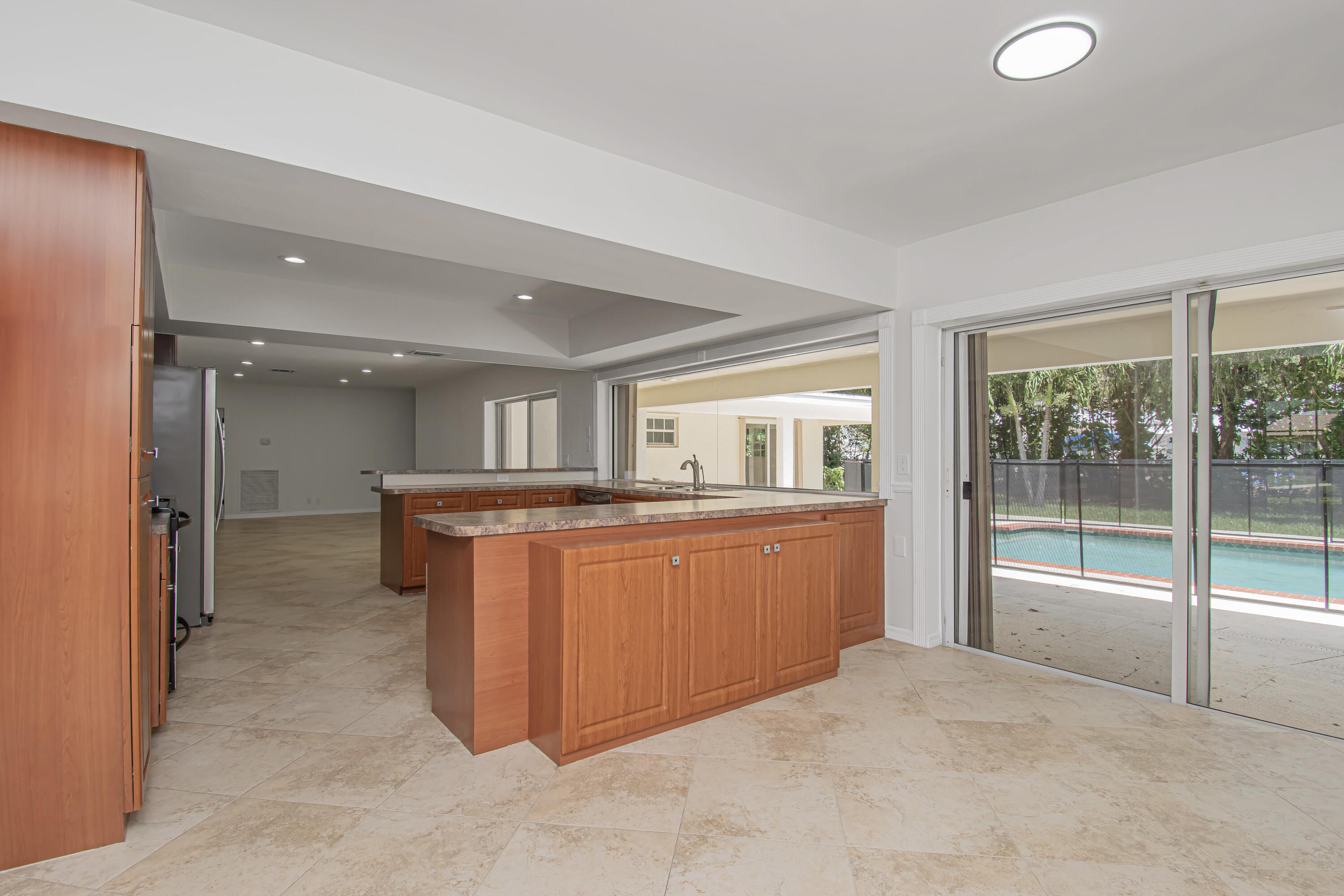 6749 South Grande Drive Boca Raton, FL 33433 - Photo 17 of 35 a room with kitchen island and large windows