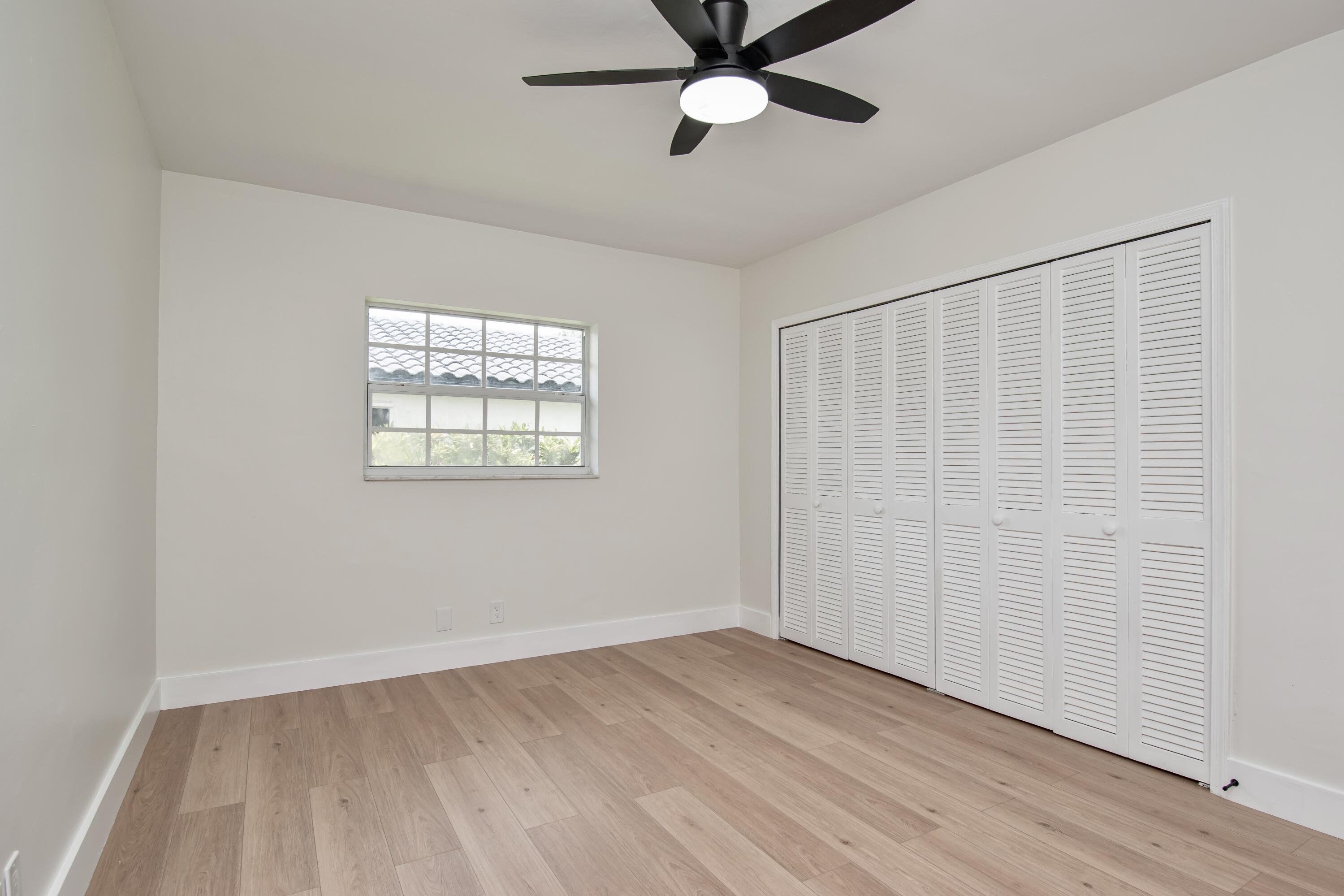 6749 South Grande Drive Boca Raton, FL 33433 - Photo 21 of 35 an empty room with wooden floor closet and windows
