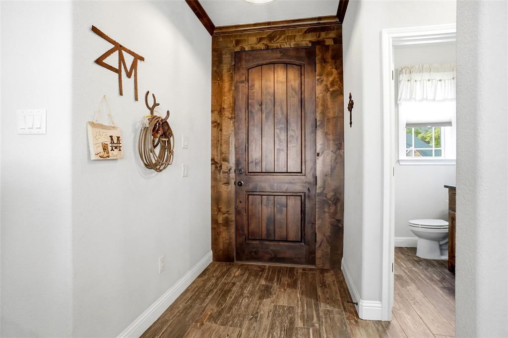 1024 Tex Lane Springtown, TX 76082 - Photo 25 of 40 a view of a hallway with wooden floor and a bathroom