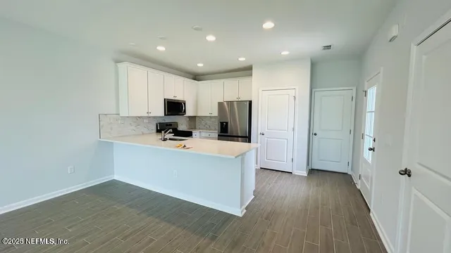 a kitchen with stainless steel appliances a refrigerator and a stove top oven