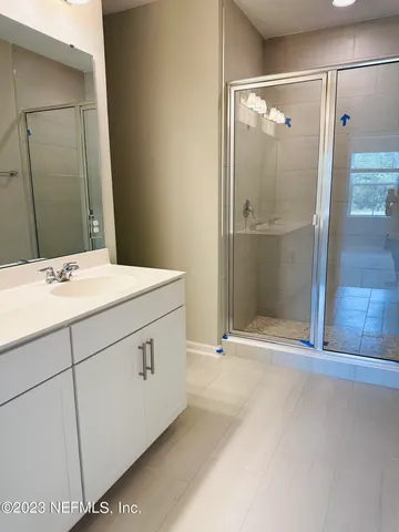 a bathroom with a shower sink and mirror