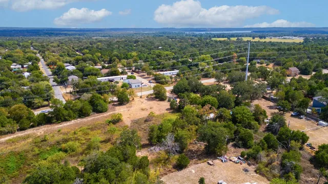 an aerial view of residential houses with outdoor space and trees
