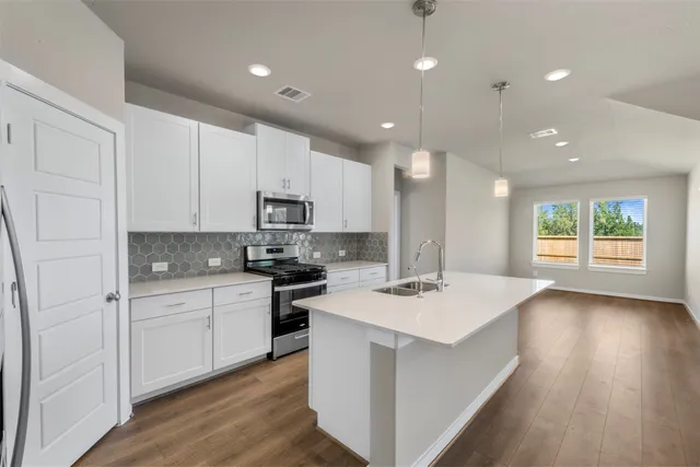 a kitchen that has a sink a stove top oven a counter space and cabinets