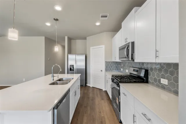 a kitchen with a sink stove and white cabinets