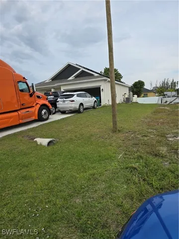 a car parked in the grass near a yard