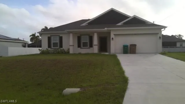 a front view of a house with a garden