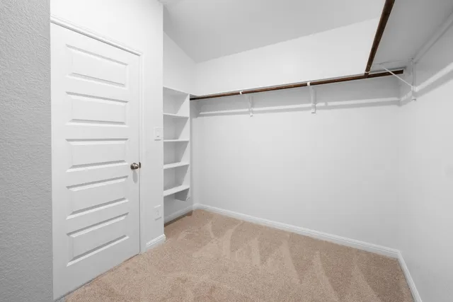 a view of walk in closet with empty racks