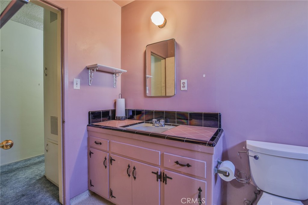 15719 Pitts Avenue Paramount, CA 90723 - Photo 20 of 33 a bathroom with a granite countertop toilet sink and mirror