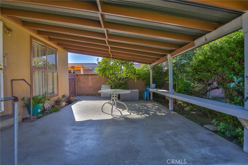 15719 Pitts Avenue Paramount, CA 90723 - Photo 29 of 33 a view of a patio with table and chairs potted plants with floor to ceiling window