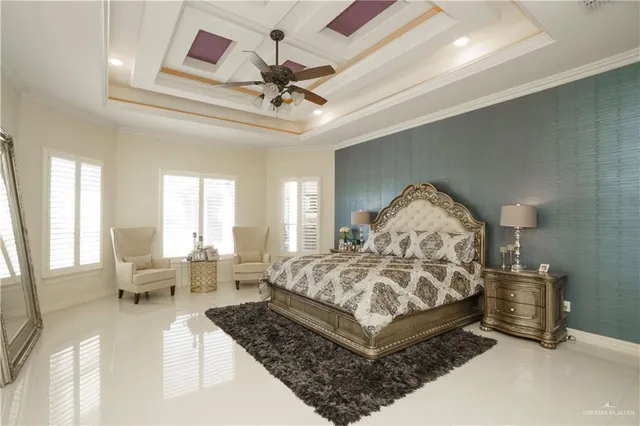 a spacious bedroom with a bed a chandelier and large window