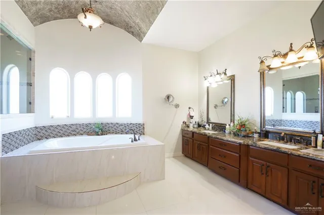 a spacious bathroom with a tub sink and mirror