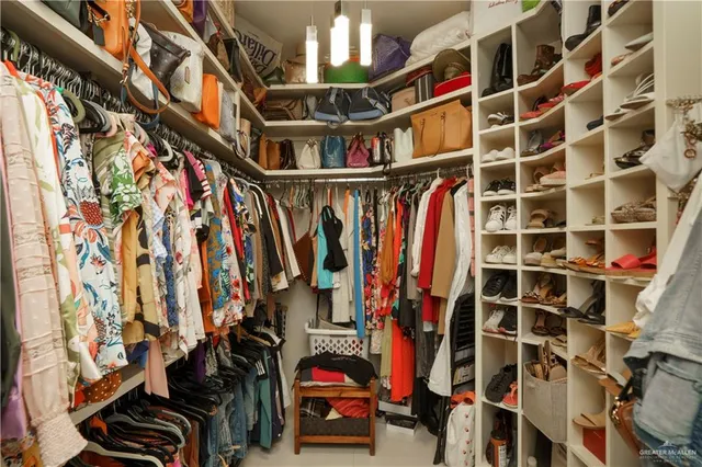 a view of walk in closet with clothes and shoes