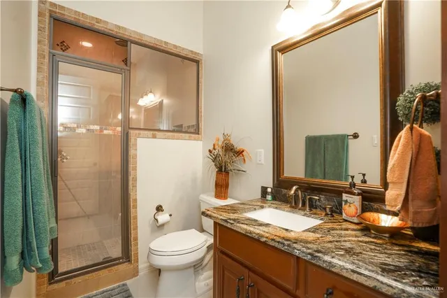 a bathroom with a granite countertop sink toilet and shower