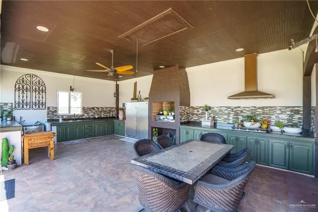 a outdoor kitchen with a table and chairs