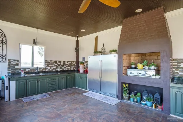 a kitchen with stainless steel appliances kitchen island granite countertop a refrigerator a stove and a wooden floors