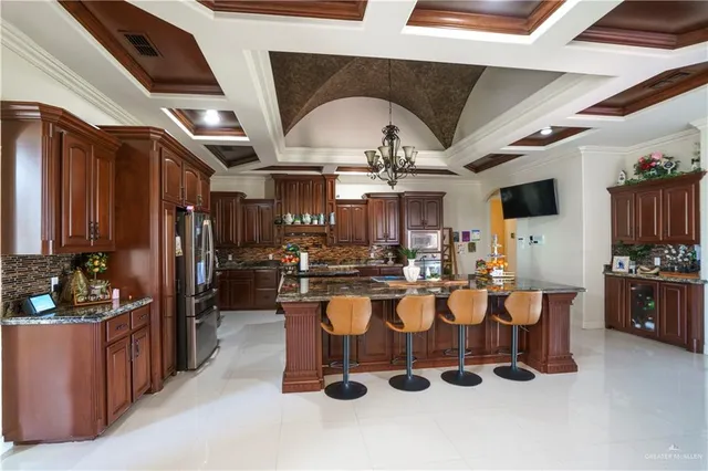 a view of a dining room with furniture a kitchen and chandelier
