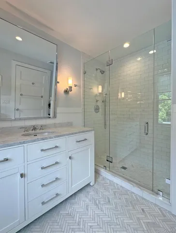 a bathroom with a granite countertop sink mirror and shower