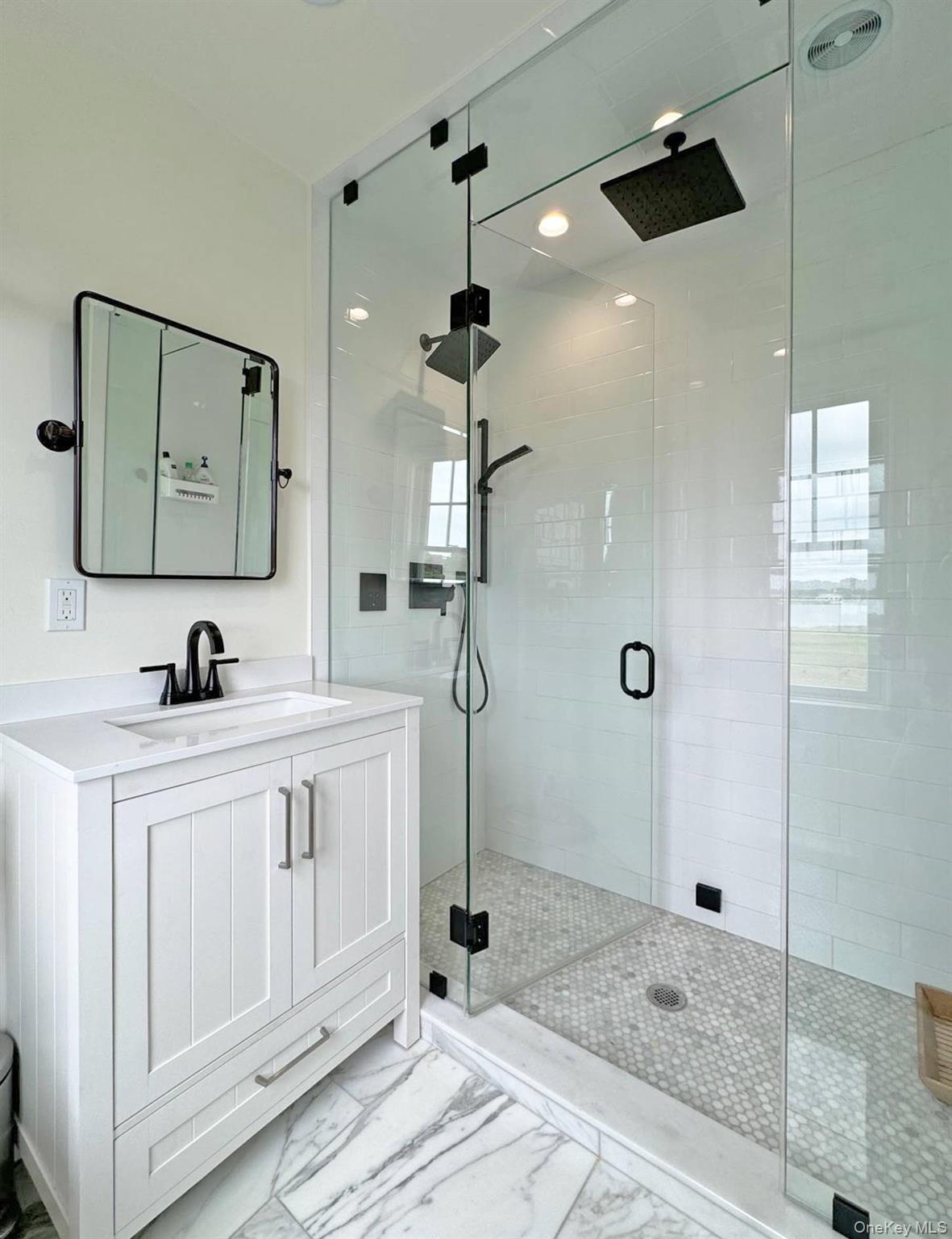 4 Sandacres Road Quogue, NY 11959 - Photo 28 of 32 a bathroom with a double vanity sink a mirror and shower