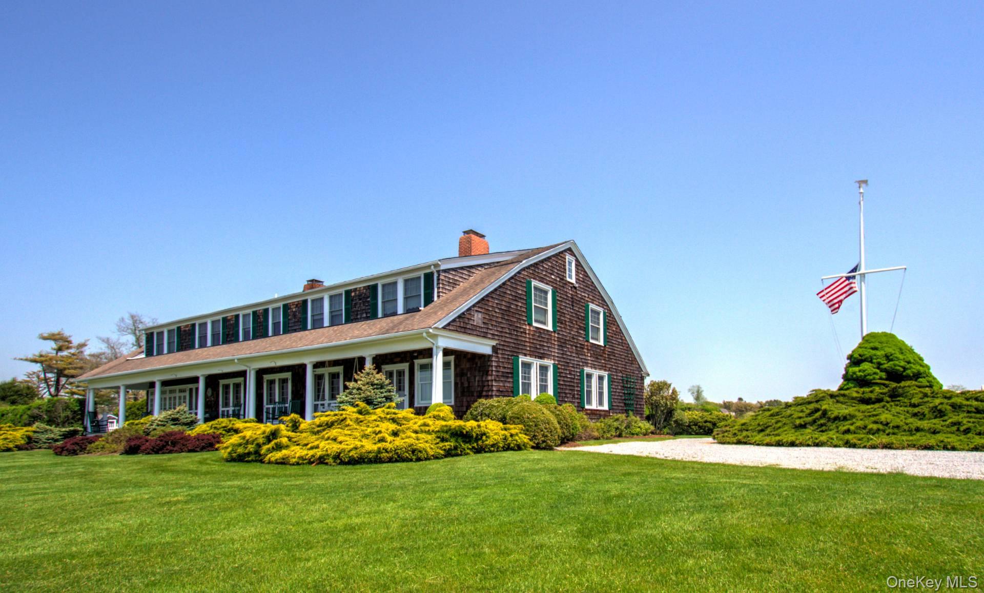 4 Sandacres Road Quogue, NY 11959 - Photo 9 of 32 a front view of a house with a yard table and chairs