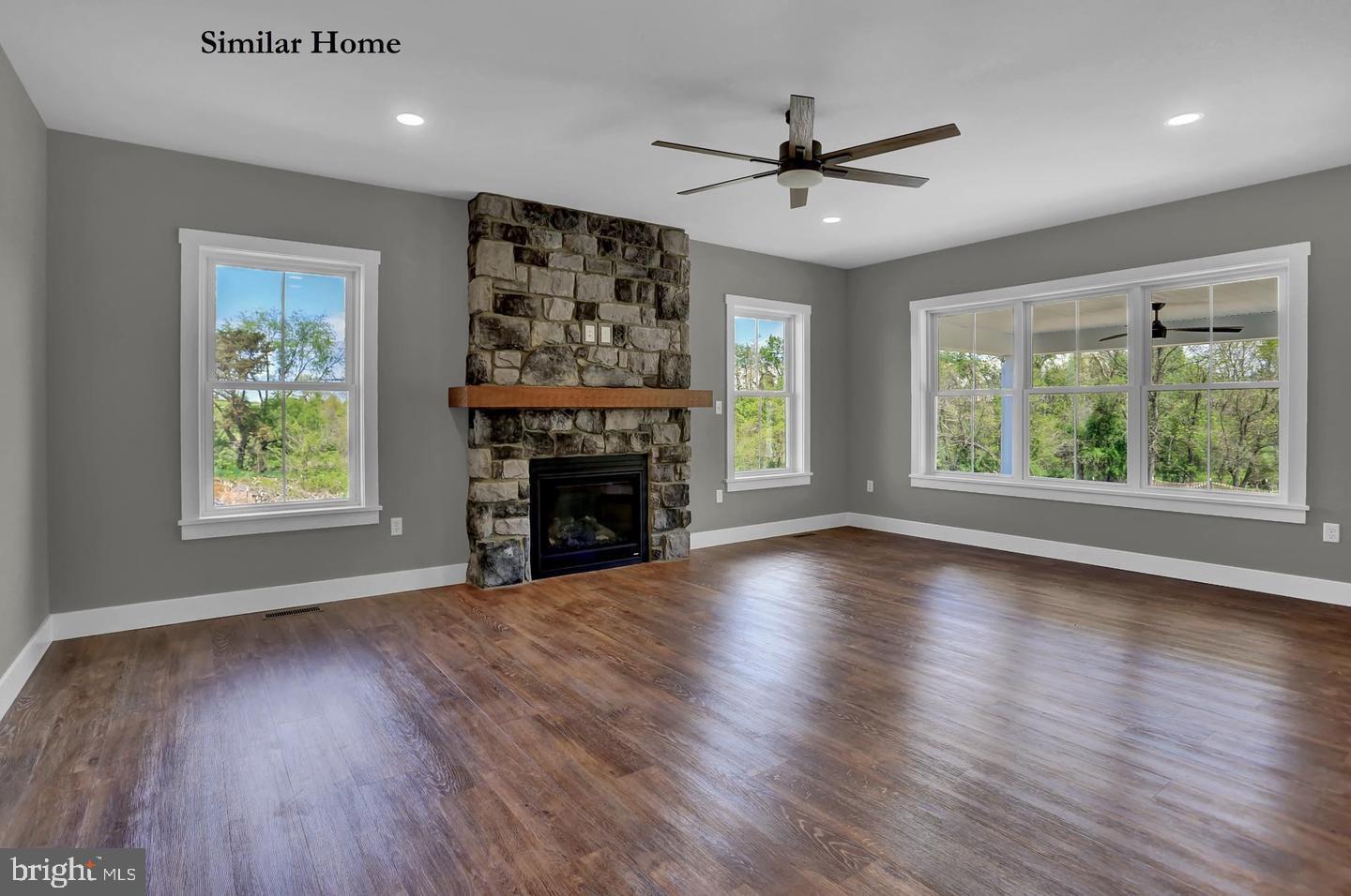 Hill Road, Unit CAMDEN New Freedom, PA 17349 - Photo 11 of 52 an empty room with windows a fireplace a ceiling fan and wooden floor