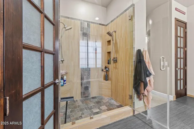 a bedroom with a bed a couch and paintings on the wall